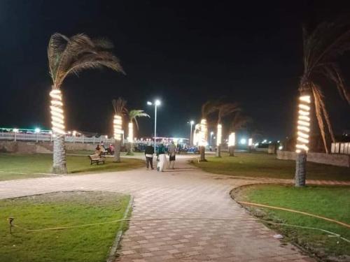 a group of people walking down a sidewalk at night at شاليه ديمورا عائلات فقط Dimora Chalet Only Family in Dawwār Muḩammad Abū Shunaynah