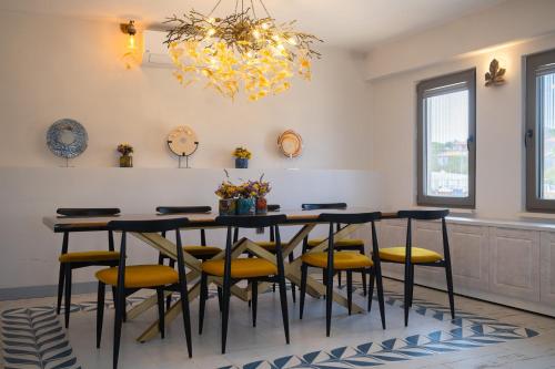 uma sala de jantar com uma mesa com cadeiras e um lustre em La Luz Hotel & Spa Bozcaada em Bozcaada