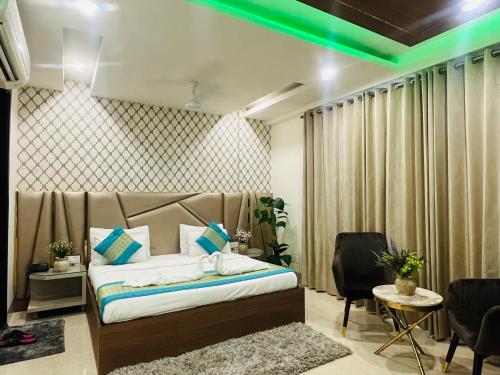 a bedroom with a bed with green lights on it at Gazebo Inn & Suites Medanta in Gurgaon