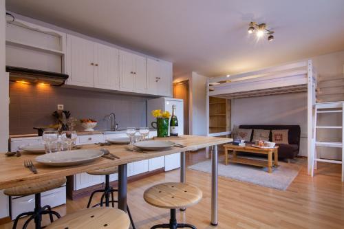 une cuisine et un salon avec une table et des chaises dans l'établissement Apt. La Larze 58 - Happy Rentals, à Chamonix-Mont-Blanc