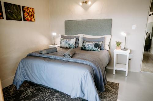 a bedroom with a large bed with blue sheets and pillows at Breathe Accommodation in Oudtshoorn