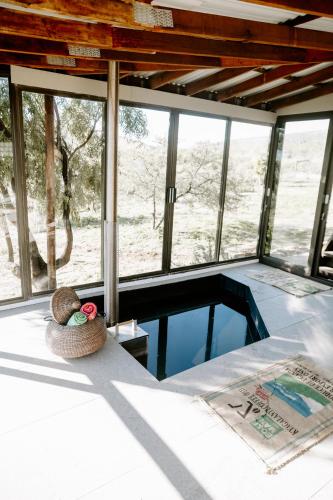 a bedroom with a view of a pool in a house at Breathe Accommodation in Oudtshoorn