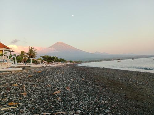 a rocky beach with a mountain in the background at Kumpul Beach in Amed