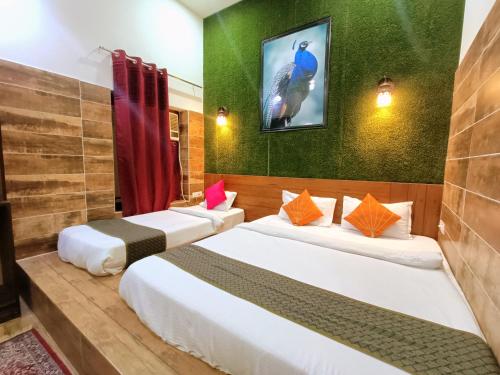 two beds in a room with a tv on the wall at The Hideout Agra - Garden Homestay near Taj in Agra