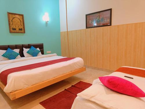 a bedroom with two beds and a tv on the wall at The Hideout Agra - Garden Homestay near Taj in Agra