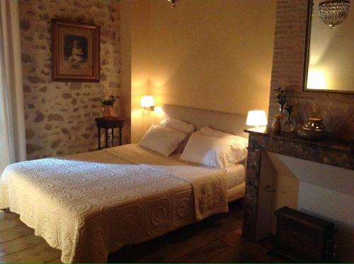 a bedroom with a white bed and a fireplace at Cardabelle Holiday Home with private garden in Mazières