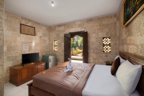 Una cama o camas en una habitación de Hotel Lumbung Sari Legian
