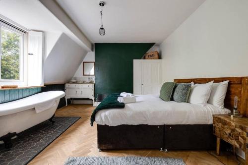 een slaapkamer met een groot bed en een bad bij Duplex Apartment - City Centre in Chester