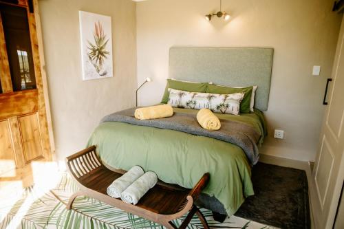 a small bedroom with a bed with towels on it at Breathe Accommodation in Oudtshoorn