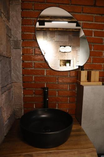 baño con lavabo negro y espejo en Oldtown Apartment in Prishtina, en Pristina