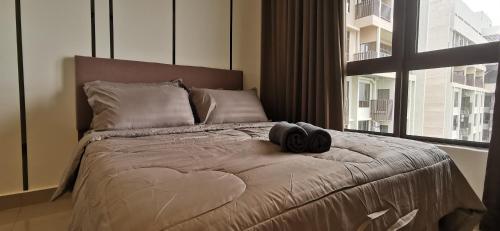a bed with a heart pillow on it with a window at Mykey Bali A-36-10 Melaka City in Melaka