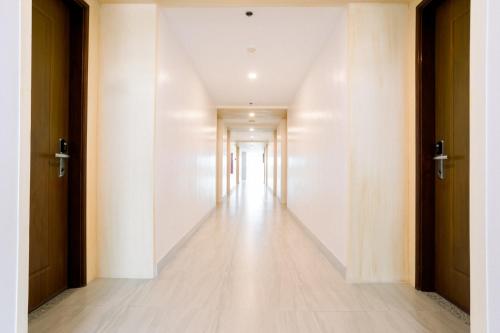 an empty hallway with white walls and wooden doors at Allure Hotel & Suites in Cebu City