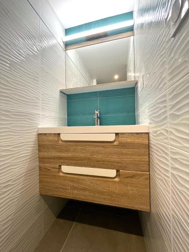 une salle de bain avec un lavabo et un miroir dans l'établissement La Vallée d'émeraude, à Plouër-sur-Rance