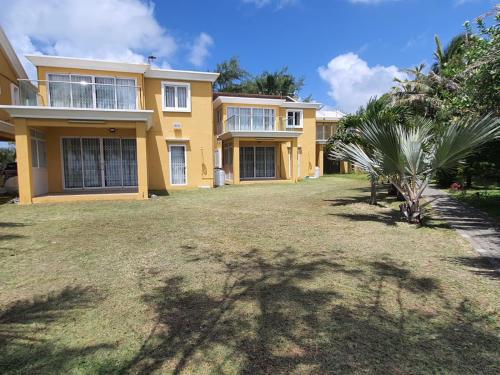 a large yellow house with a large yard at Ocean villa in Palmar