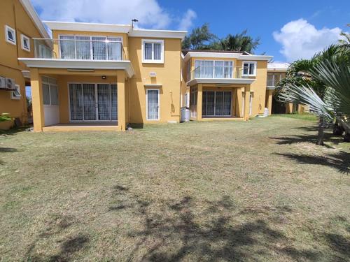 a large yellow house with a yard in front of it at Ocean villa in Palmar
