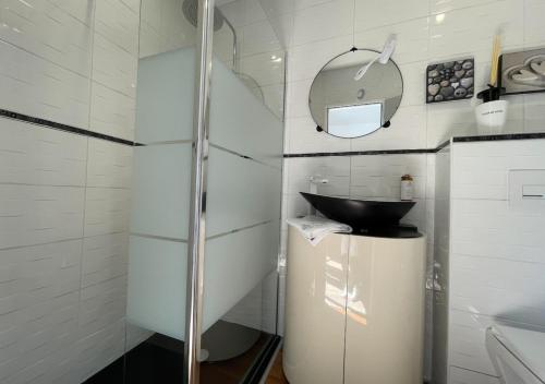 uma casa de banho com uma cabina de duche em vidro e um lavatório. em Le 36 Maison d'hôtes Piscine & Spa em La Flotte