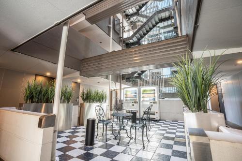 a lobby with a table and chairs and plants at HOTEL MYSTAYS Hamamatsucho in Tokyo