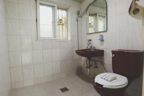 a bathroom with a toilet and a sink at Daoljae Hanok Pension in Suncheon