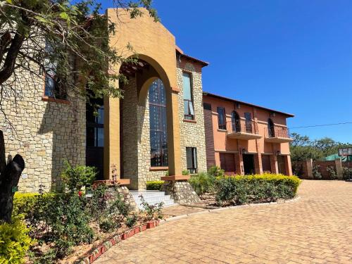 a brick building with an arched window and a brick driveway at Gucci Manor Boutique Guesthouse in Polokwane