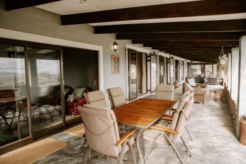 a dining room with a wooden table and chairs at Breathe Accommodation in Oudtshoorn