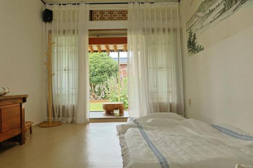 a bedroom with a bed and a large window at Daoljae Hanok Pension in Suncheon