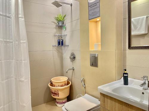 a bathroom with a sink and a toilet and a shower at Bedchambers Serviced Apartments, Ardee City in Gurgaon