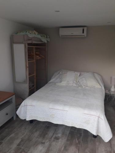 een slaapkamer met een wit bed en een dressoir bij logement individuel in Le Cannet