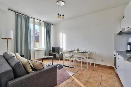 ein Wohnzimmer mit einem Sofa und einem Tisch in der Unterkunft Appartement beau confort in Saint-Fons