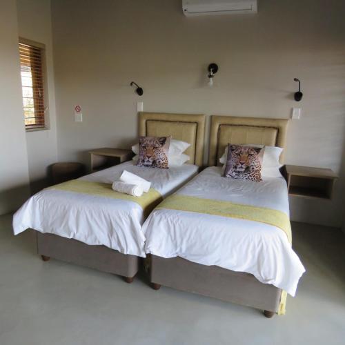 two beds sitting next to each other in a bedroom at Kanaan, Mabalingwe in Mabula