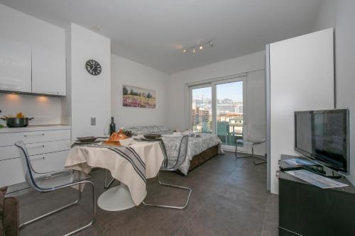 eine Küche und ein Wohnzimmer mit einem Bett und einem TV in der Unterkunft Sunrise House - Happy Rentals in Lugano