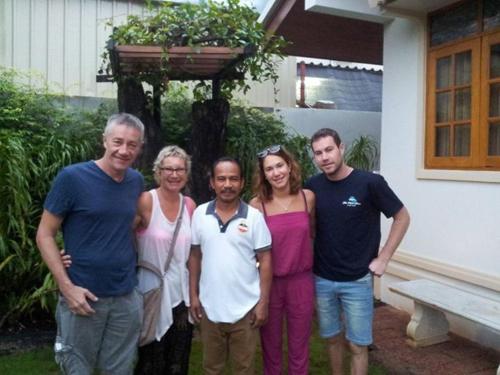 a group of people standing in front of a house at Tree Home Plus in Nakhon Si Thammarat