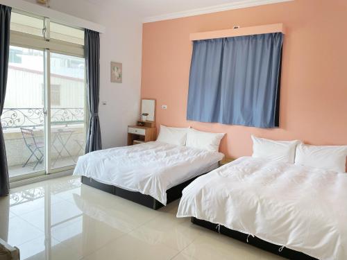 sypialnia z 2 łóżkami i oknem w obiekcie 薇琪小屋 w mieście Hualian