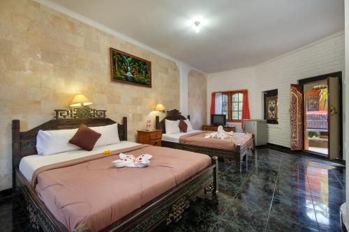 Postel nebo postele na pokoji v ubytování Hotel Lumbung Sari Legian