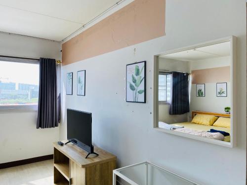 ein Wohnzimmer mit einem Spiegel und einem TV in der Unterkunft Condo popular T8 fl.6 in Thung Si Kan