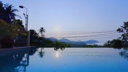 a large pool of water with mountains in the background at Mantra Sea View Villa in Chaloklum