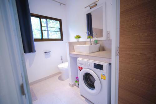 a bathroom with a washing machine and a sink at Mantra Sea View Villa in Chaloklum