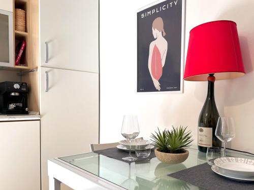 a red lamp sitting on a glass table with wine glasses at Centralissimo - Nuovo - Parcheggio Privato in Perugia