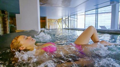 a young woman laying in a hot tub at Auberge de Jeunesse HI Serre-Chevalier in La Salle Les Alpes