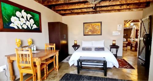 een slaapkamer met een bed, een tafel en een bureau bij Ugly Darling Farmstyle B&B in Krugersdorp