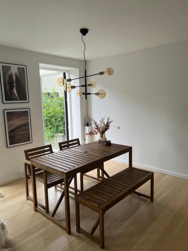 Charmerende 3-værelses lejlighed في كوبنهاغن: غرفة طعام مع طاولة وكراسي خشبية