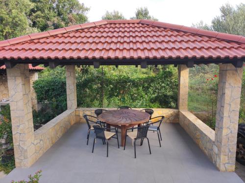 a gazebo with a table and chairs on a patio at Olive Island Apartments & Resort, 3 Stars Family Friendly in Neviđane