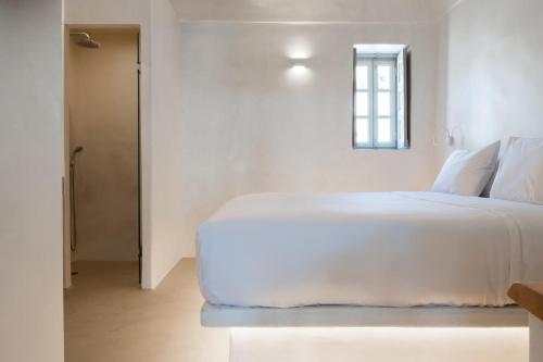 a bedroom with a large white bed and a window at Grandma's Houses in Éxo Goniá
