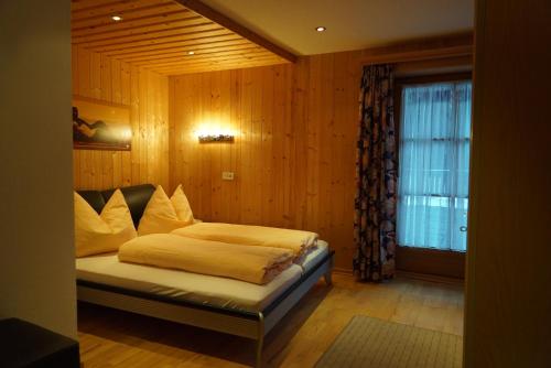 ein Schlafzimmer mit einem Bett und einem Fenster in der Unterkunft Gasthof Perfler in Außervillgraten