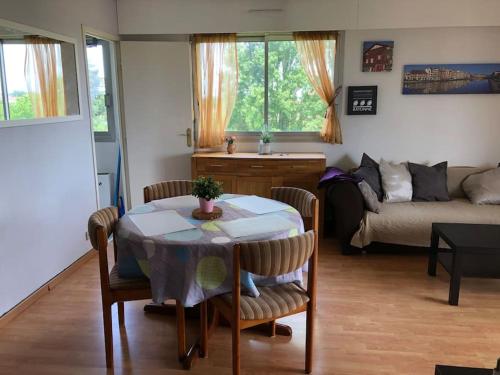 a living room with a table and a couch at Appartement lumineux BAYONNE in Bayonne