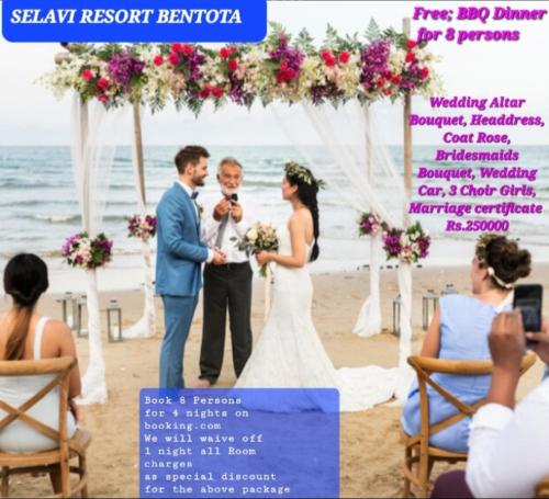 Selavi Resort Bentota في بينتوتا: عروس وعريس واقفين تحت قوس عرس على الشاطئ