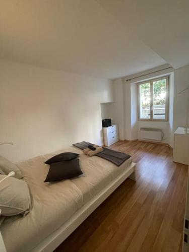 ein großes Bett in einem weißen Zimmer mit Fenster in der Unterkunft Schöne Wohnung in der Via Borgo in Ascona