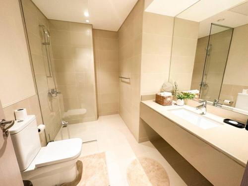 uma casa de banho com um WC, um lavatório e um espelho. em Casa Dei Ricordi 620WB8 em Abu Dhabi