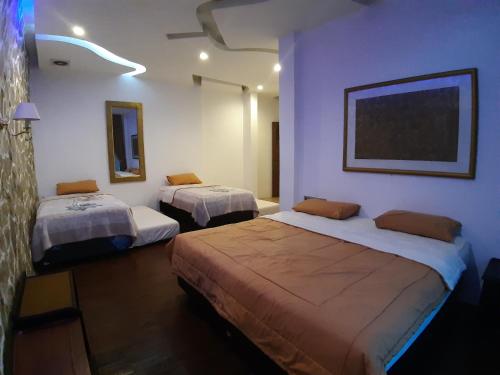 a room with two beds and a painting on the wall at De Summit Villa & View in Puncak