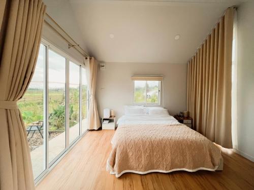 a bedroom with a bed and a large window at Northland Pai in Pai