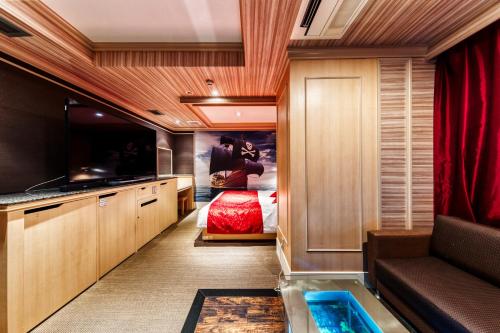 a hotel room with a bed and a tub in a room at Hotel Atlantis Machida -Adult Only in Kami-seya